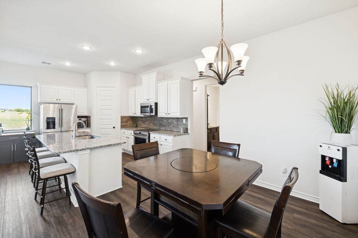 108 Santa Teresa Road Kyle, TX 78640 - Photo 10 of 26 a view of a dining room and livingroom with furniture wooden floor a chandelier