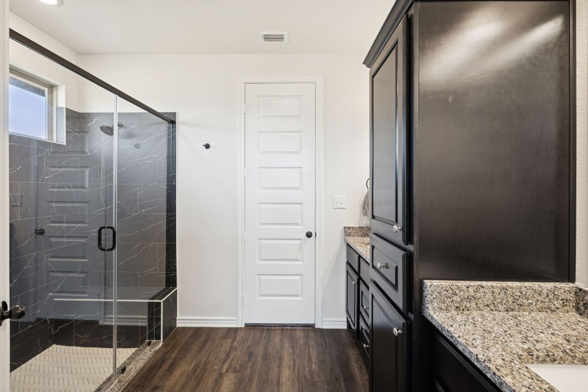 108 Santa Teresa Road Kyle, TX 78640 - Photo 15 of 26 a kitchen with granite countertop a refrigerator and wooden floor