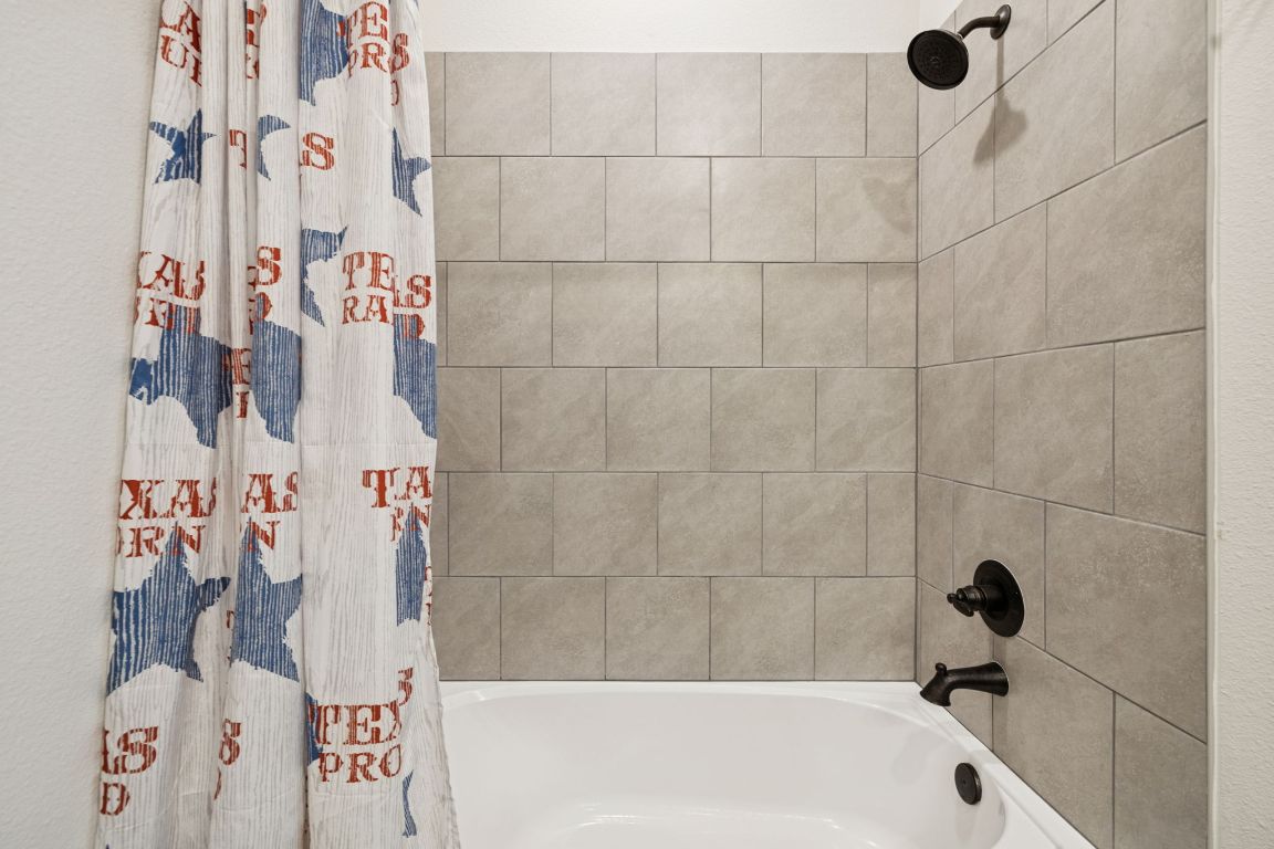 108 Santa Teresa Road Kyle, TX 78640 - Photo 18 of 26 a bathroom with a bathtub and shower