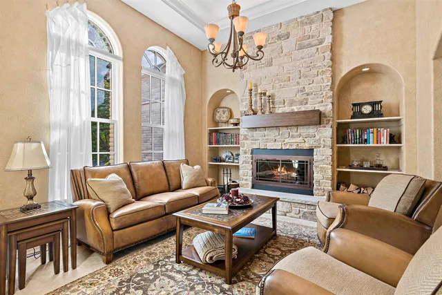 a living room with furniture fireplace and a large window