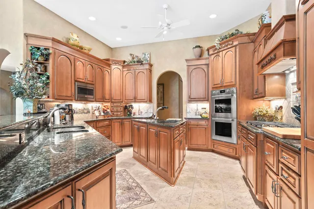 a kitchen with stainless steel appliances granite countertop a stove and a sink