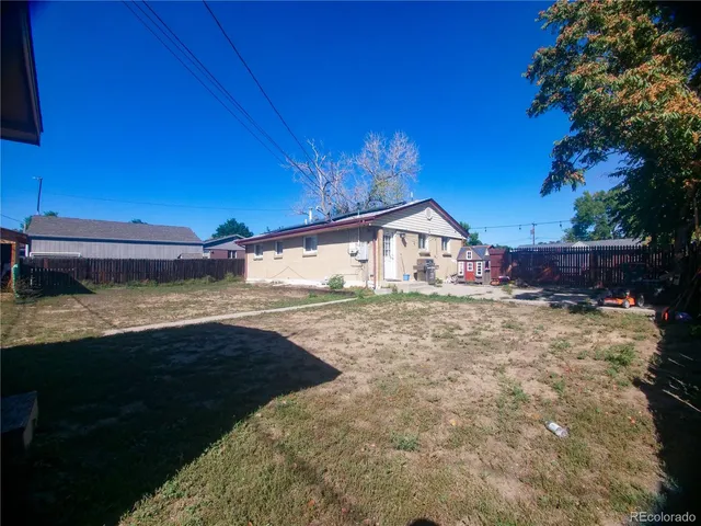 a view of a house with backyard and sitting area