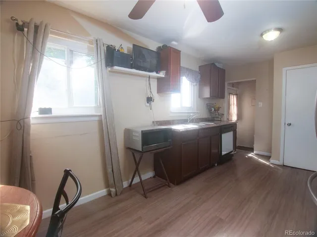 a kitchen with stainless steel appliances granite countertop a stove a sink dishwasher a refrigerator with wooden cabinets and wooden floor