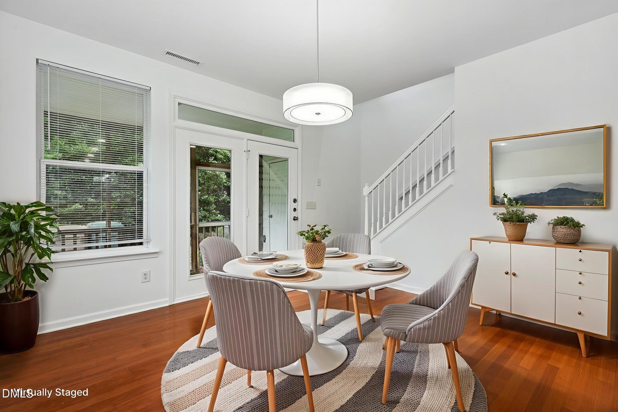 3141 Rapid Falls Road Cary, NC 27519 - Photo 12 of 28 a dining room with wooden floor a chandelier a wooden table and chairs