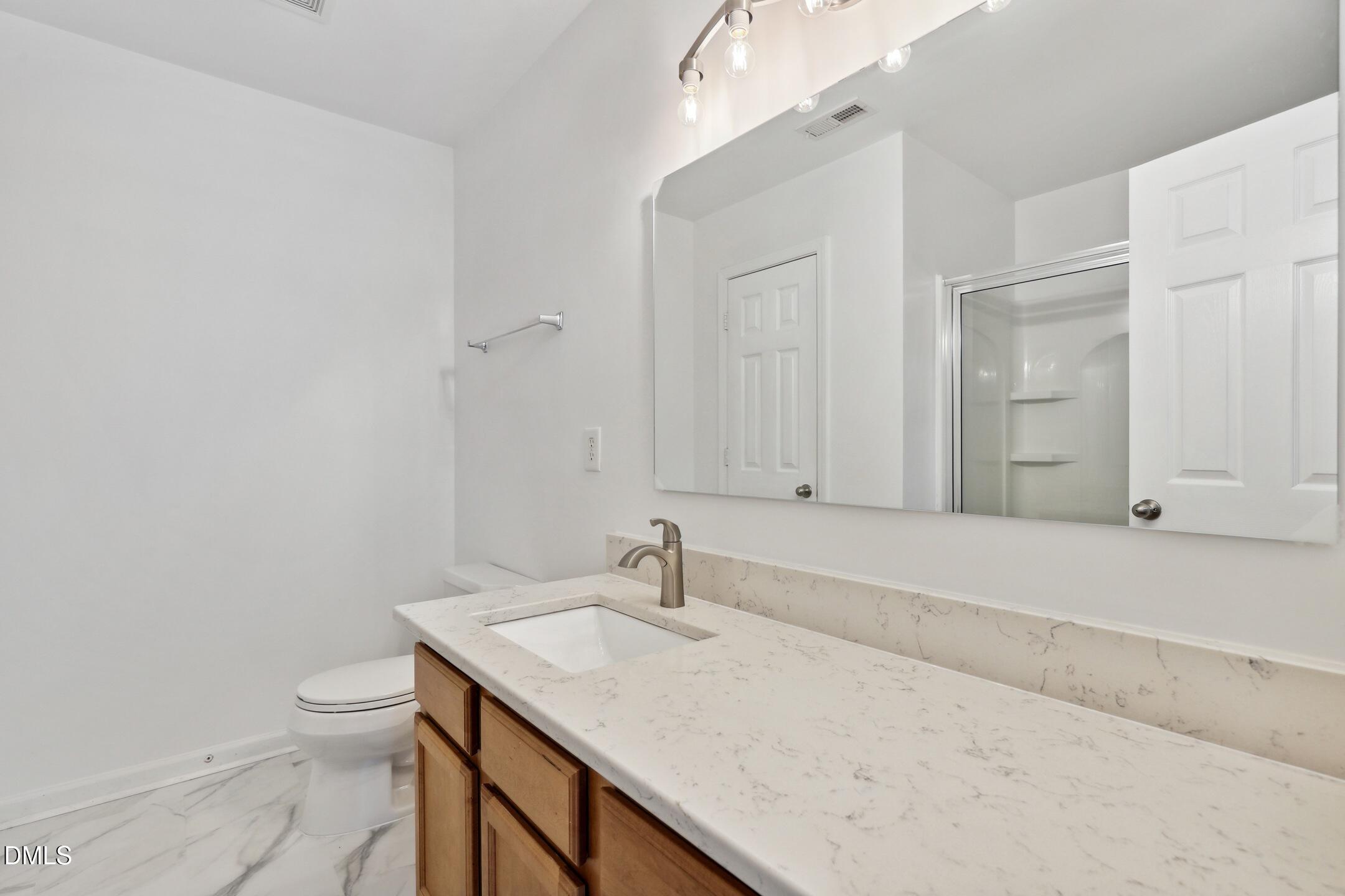 3141 Rapid Falls Road Cary, NC 27519 - Photo 20 of 28 a bathroom with a granite countertop sink a toilet and with a vanity