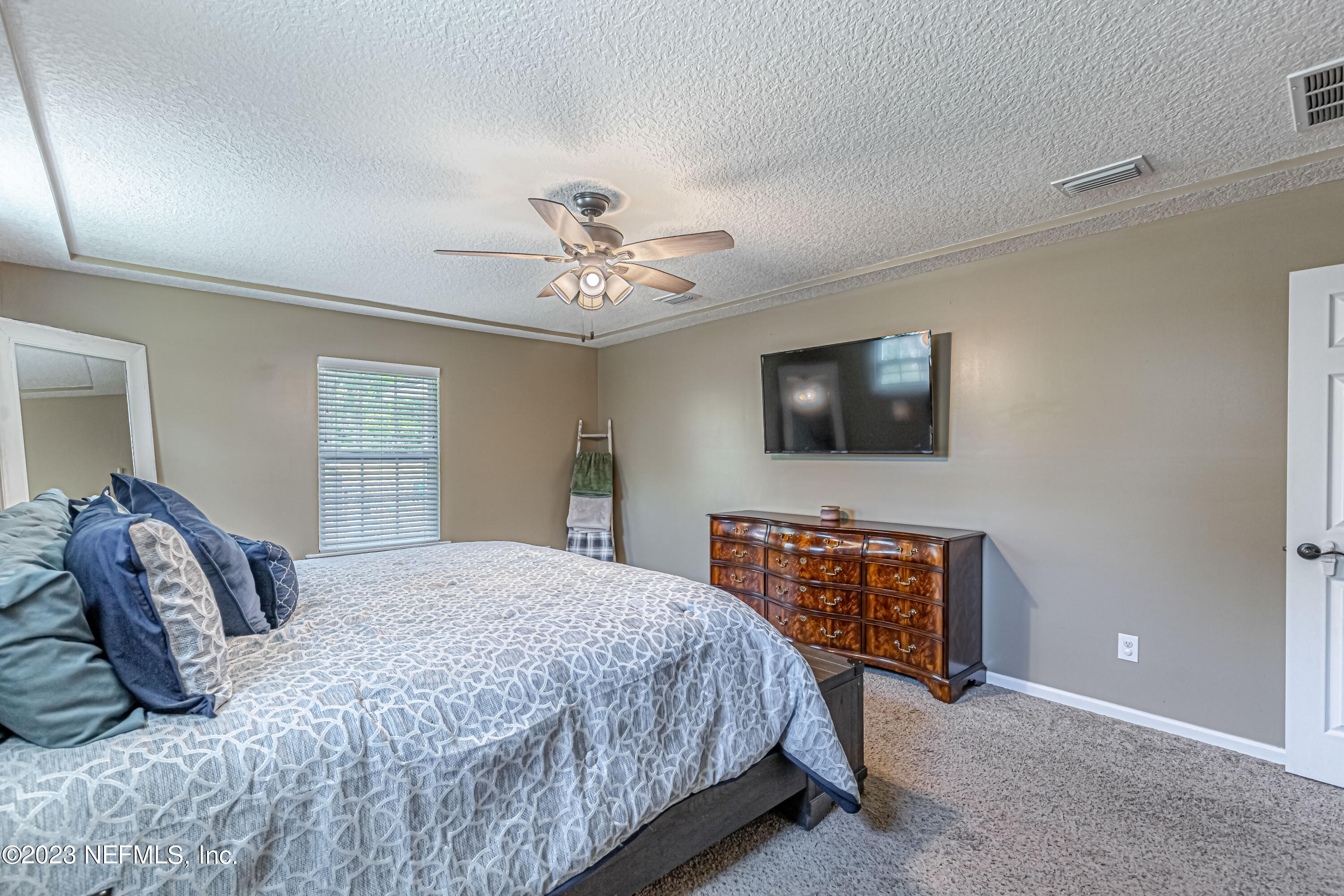 1199 Hatcher Road Middleburg, FL 32068 - Photo 31 of 55 a bedroom with a bed and a flat screen tv