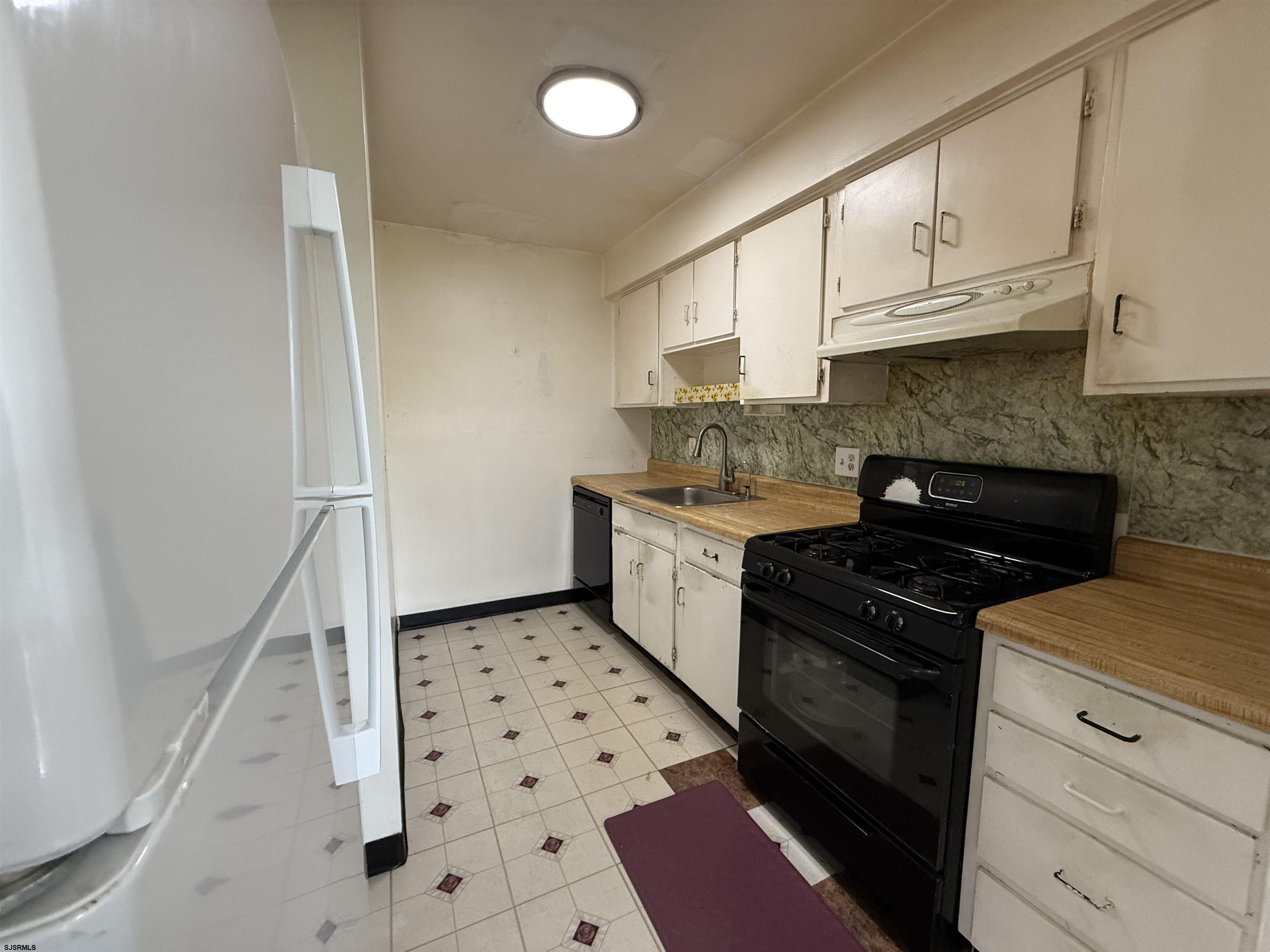 720 South New Road, Unit 3L Absecon, NJ 08201 - Photo 11 of 25 a kitchen with granite countertop a stove a sink and a refrigerator