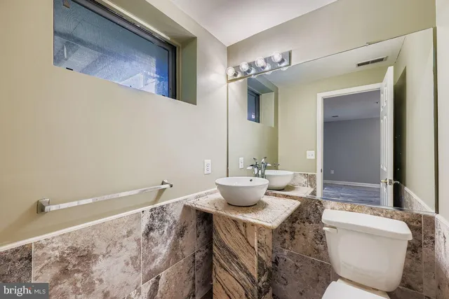 a bathroom with a toilet a sink and mirror