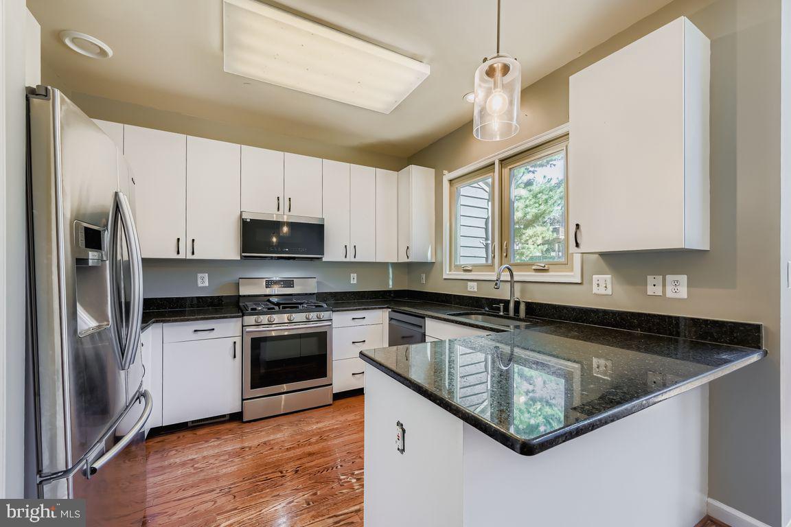 21 Stridesham Court Baltimore, MD 21209 - Photo 2 of 22 a kitchen with stainless steel appliances granite countertop a sink a stove a refrigerator cabinets and a window