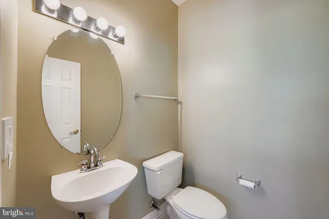 a bathroom with a toilet a sink and mirror