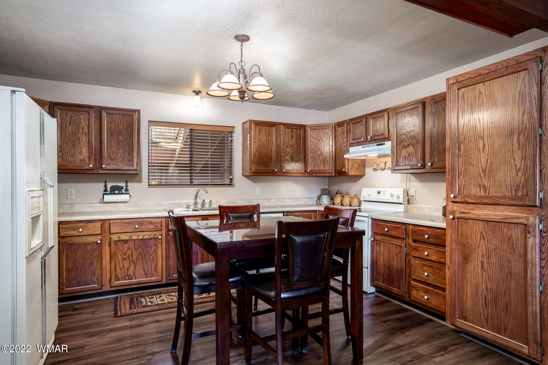2840 Lodgepole Road Overgaard, AZ 85933 - Photo 12 of 30 a kitchen with stainless steel appliances granite countertop wooden cabinets a stove a sink dishwasher and a refrigerator with wooden floor
