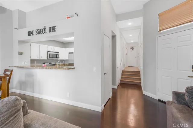 a hallway with a white cabinets and wooden floor