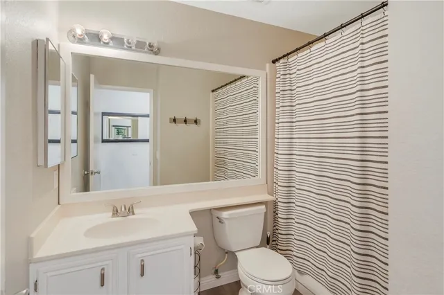 a bathroom with a toilet a sink and a mirror