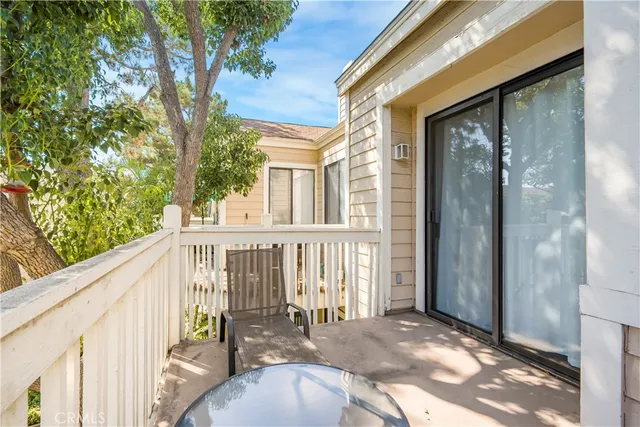 a view of a balcony with wooden floor and fence