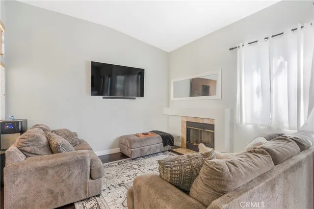 a living room with couches a fireplace and a flat screen tv