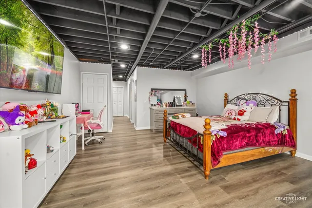 a bedroom with bed and wooden floor