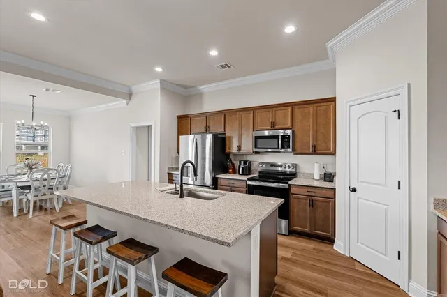 a kitchen with a refrigerator a stove and white cabinets with wooden floor