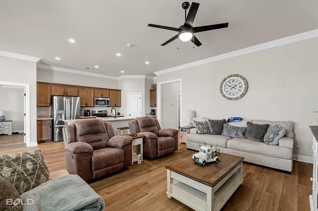 a living room with furniture a flat screen tv and a window