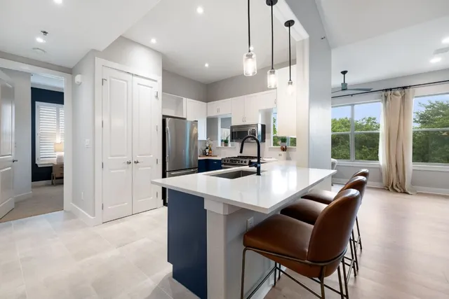 a large kitchen with kitchen island a large counter top space a sink stainless steel appliances and cabinets