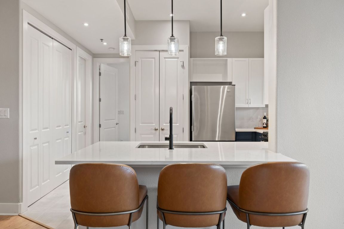 2216 Thornton Road, Unit 431 Austin, TX 78704 - Photo 14 of 30 a kitchen with stainless steel appliances granite countertop a table chairs and a refrigerator