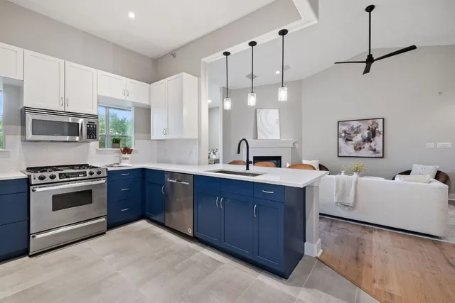 a kitchen with stainless steel appliances granite countertop a sink and a stove