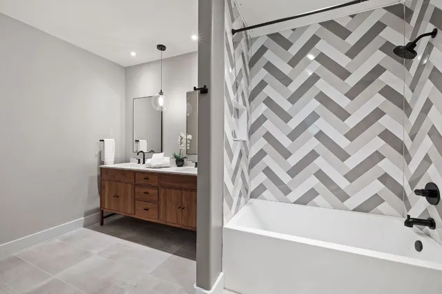 a bathroom with a double vanity sink a mirror and a bathtub