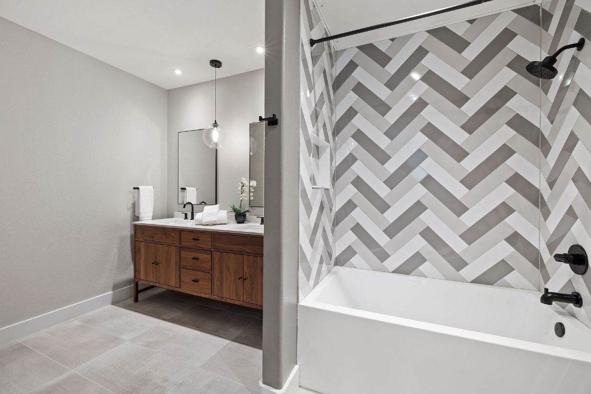 2216 Thornton Road, Unit 431 Austin, TX 78704 - Photo 20 of 30 a bathroom with a double vanity sink a mirror and a bathtub