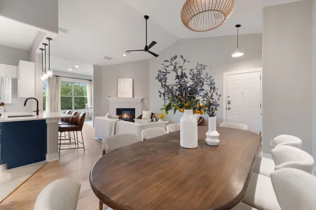 a dining room with wooden floor a chandelier a wooden table and chairs