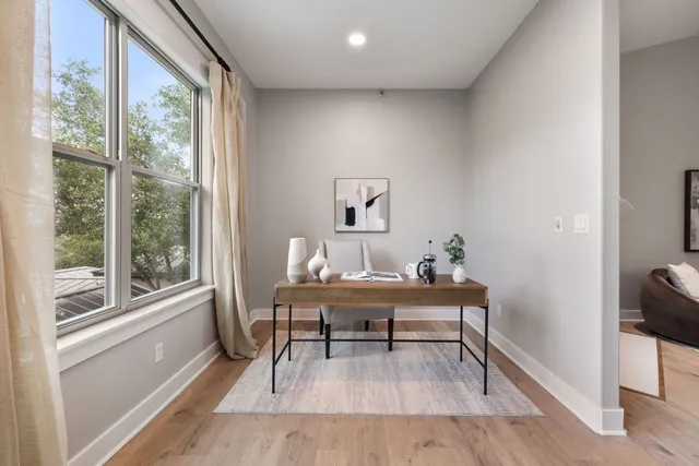 a view of a workspace with furniture and a window