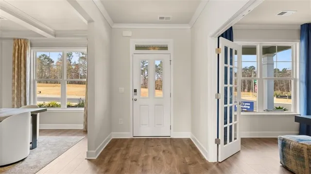 a view of a livingroom with wooden floor and windows