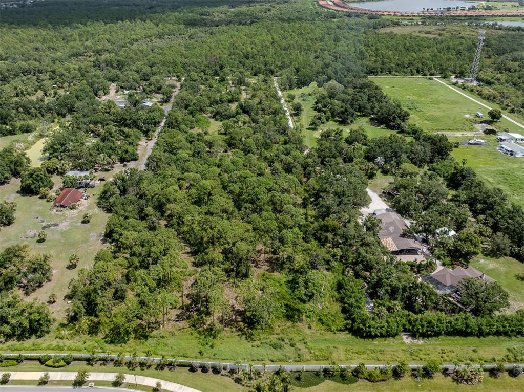 an aerial view of residential houses with outdoor space and trees