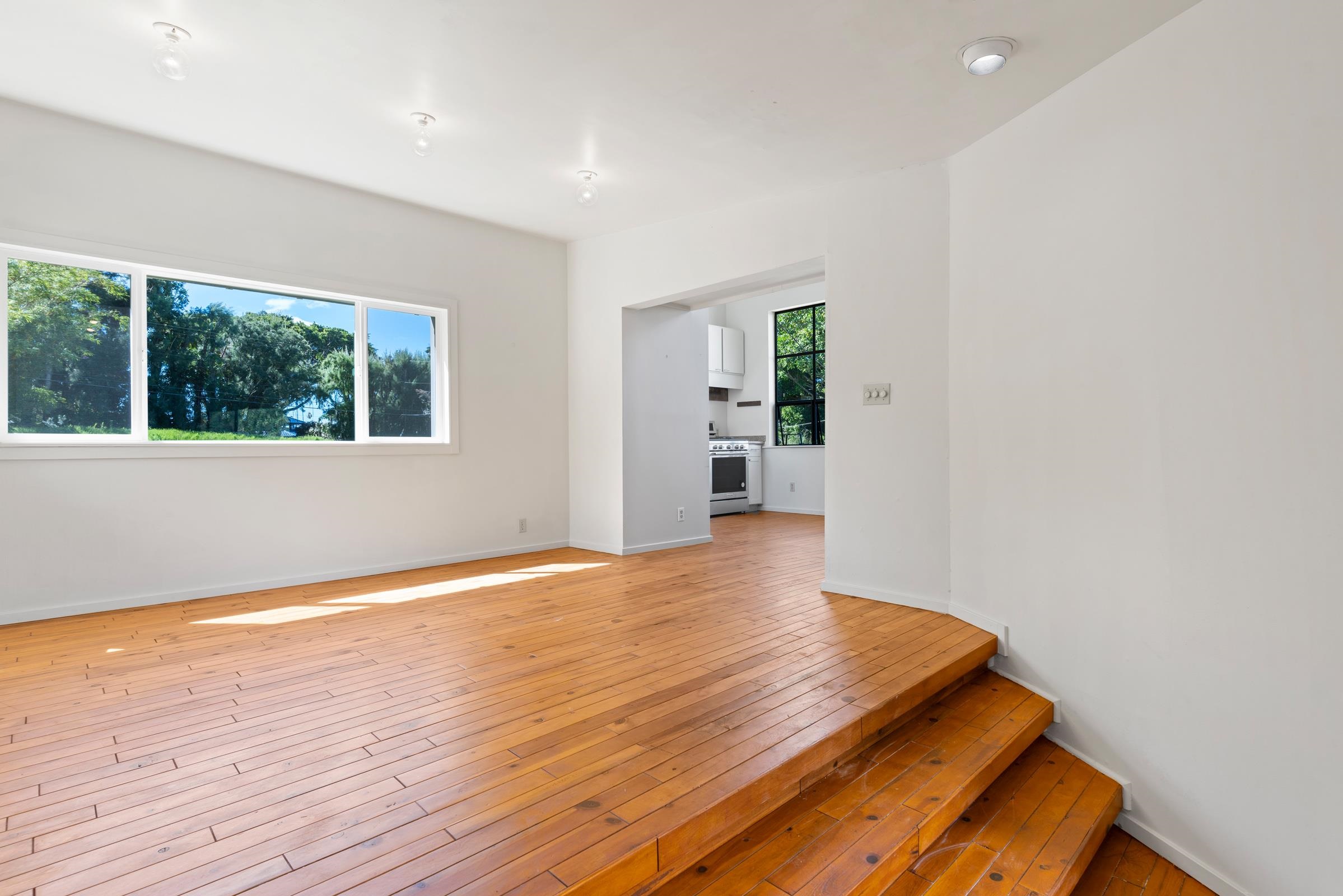 575 Awalau Road Haiku, HI 96708 - Photo 17 of 50 an empty room with wooden floor and windows
