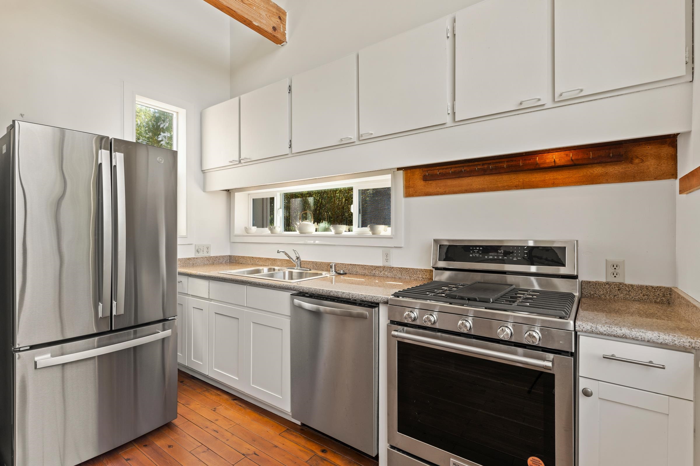 575 Awalau Road Haiku, HI 96708 - Photo 9 of 50 a kitchen with stainless steel appliances white cabinets and a stove top oven