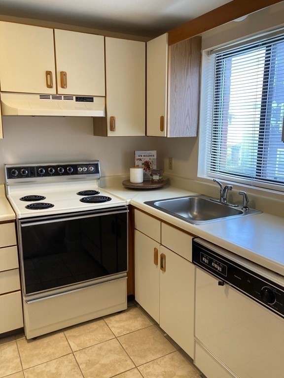 72 School Street, Unit 5 Everett, MA 02149 - Photo 14 of 21 a kitchen with stainless steel appliances a stove a microwave and cabinets