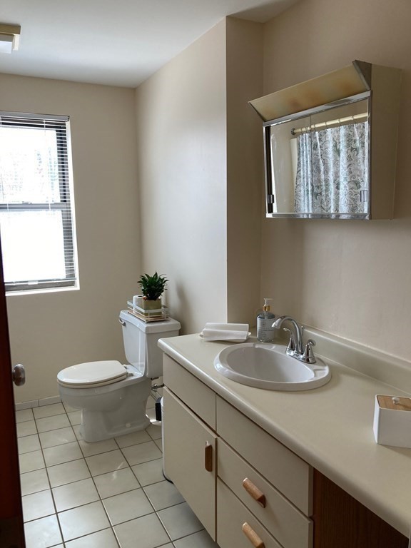 72 School Street, Unit 5 Everett, MA 02149 - Photo 16 of 21 a bathroom with a toilet a sink a mirror and a window