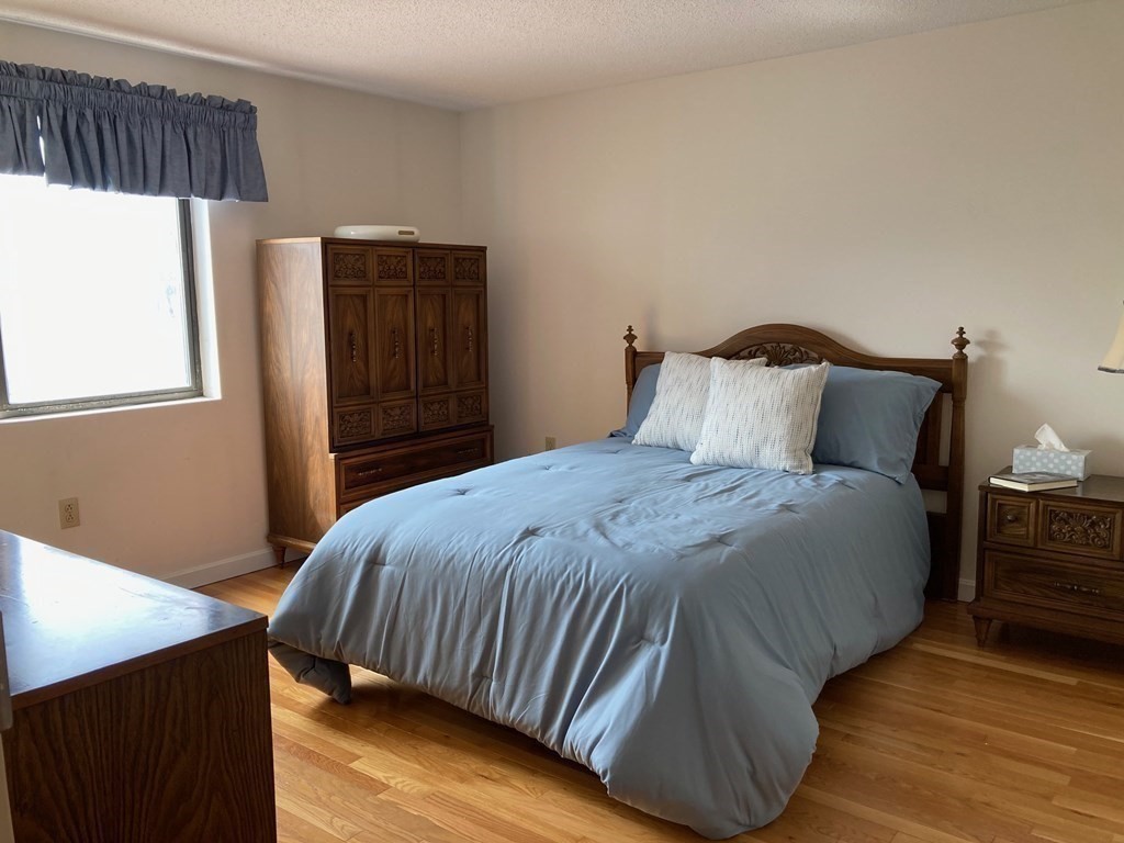 72 School Street, Unit 5 Everett, MA 02149 - Photo 9 of 21 a bedroom with a bed and wooden floor