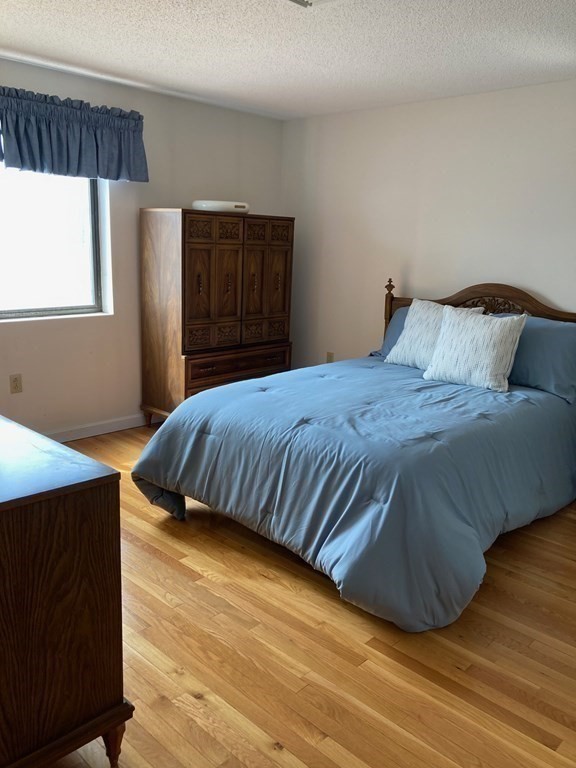 72 School Street, Unit 5 Everett, MA 02149 - Photo 10 of 21 a bedroom with a bed and wooden floor