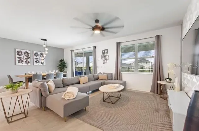 a living room with furniture and a large window with garden view