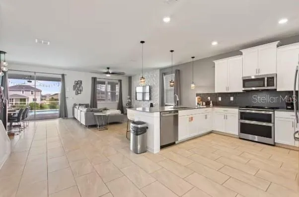 a large white kitchen with cabinets and chairs