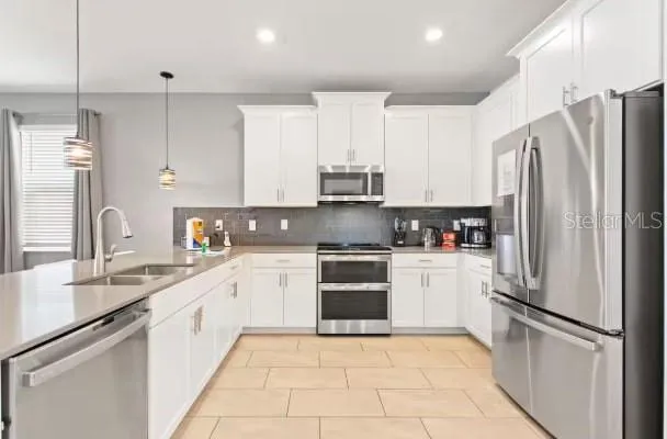 a kitchen with stainless steel appliances granite countertop a refrigerator sink and stove