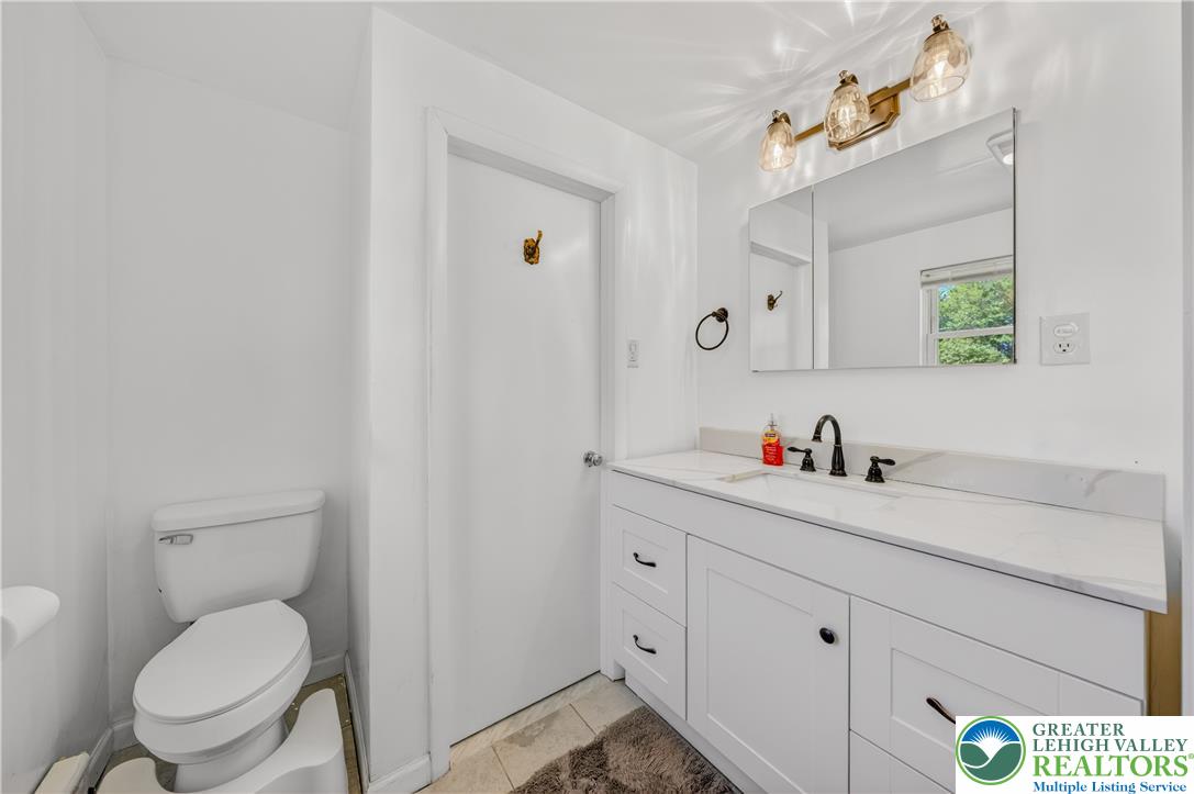 1411 Lieb Road Easton, PA 18040 - Photo 26 of 46 A well-lit lavatory features a crisp white vanity and contemporary fixtures.