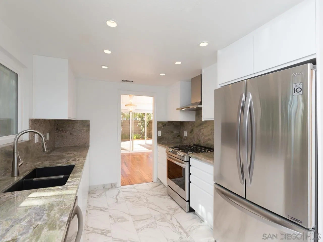 1804 Caminito Ascua La Jolla, CA 92037 - Photo 4 of 20 a kitchen with granite countertop a refrigerator and a stove top oven