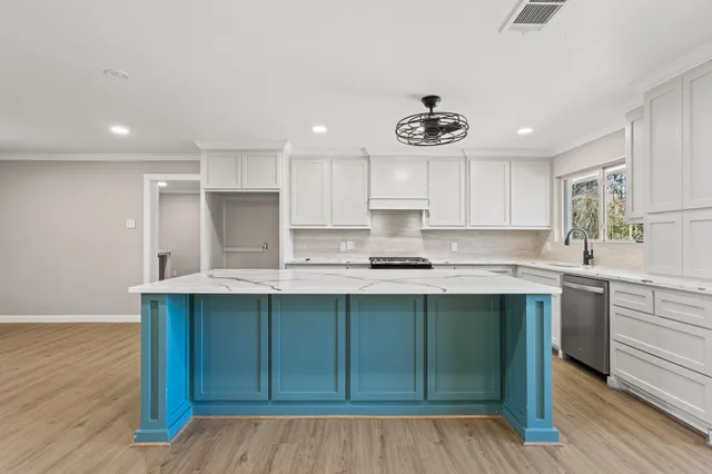 a kitchen with stainless steel appliances granite countertop a sink cabinets and wooden floor