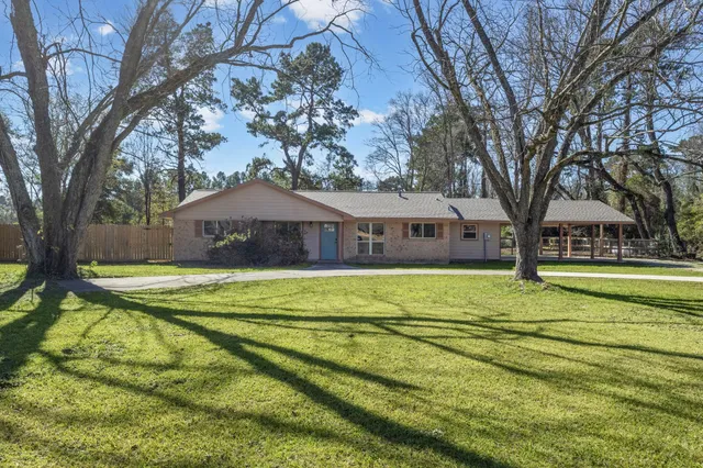 a front view of house with yard and trees