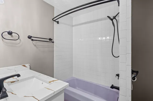 a bathroom with a sink vanity and shower