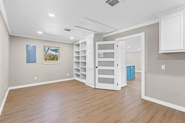 a view of empty room with wooden floor and window