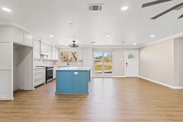 a large kitchen with a refrigerator and a stove top oven