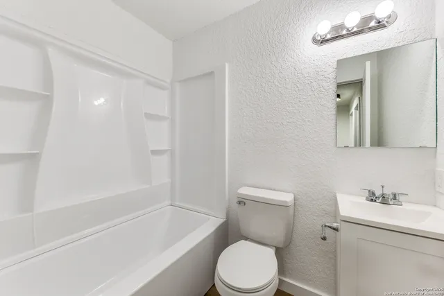 a white toilet sitting next to a bath tub