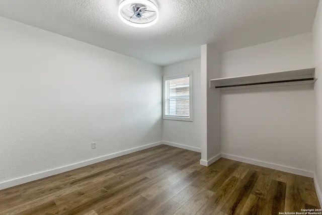 a view of a room with wooden floor and a window