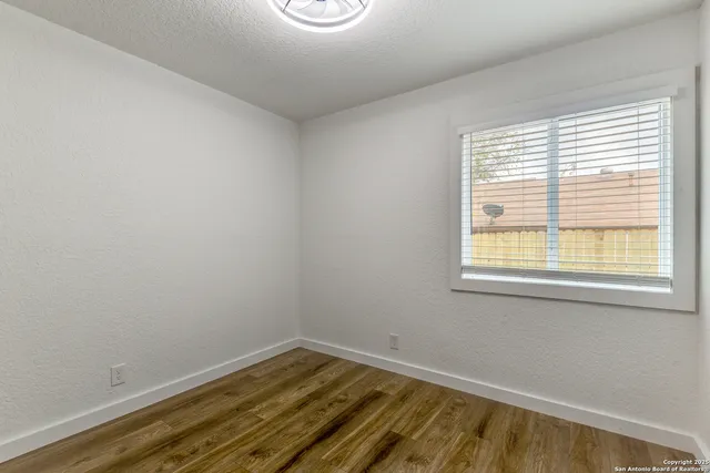 a view of a room with wooden floor and a window